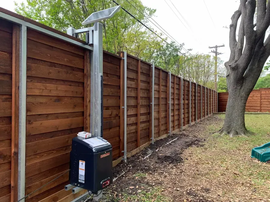 Horizontal cedar privacy fence on steel posts with an automatic gate operator