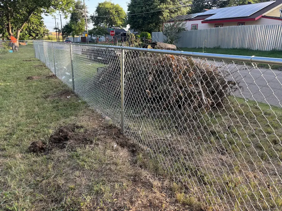 Galvanized chain link fence along a residential yard